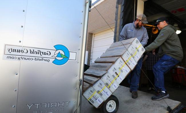 Garfield County staff roll a stack of ballots into the post office in Glenwood Springs.